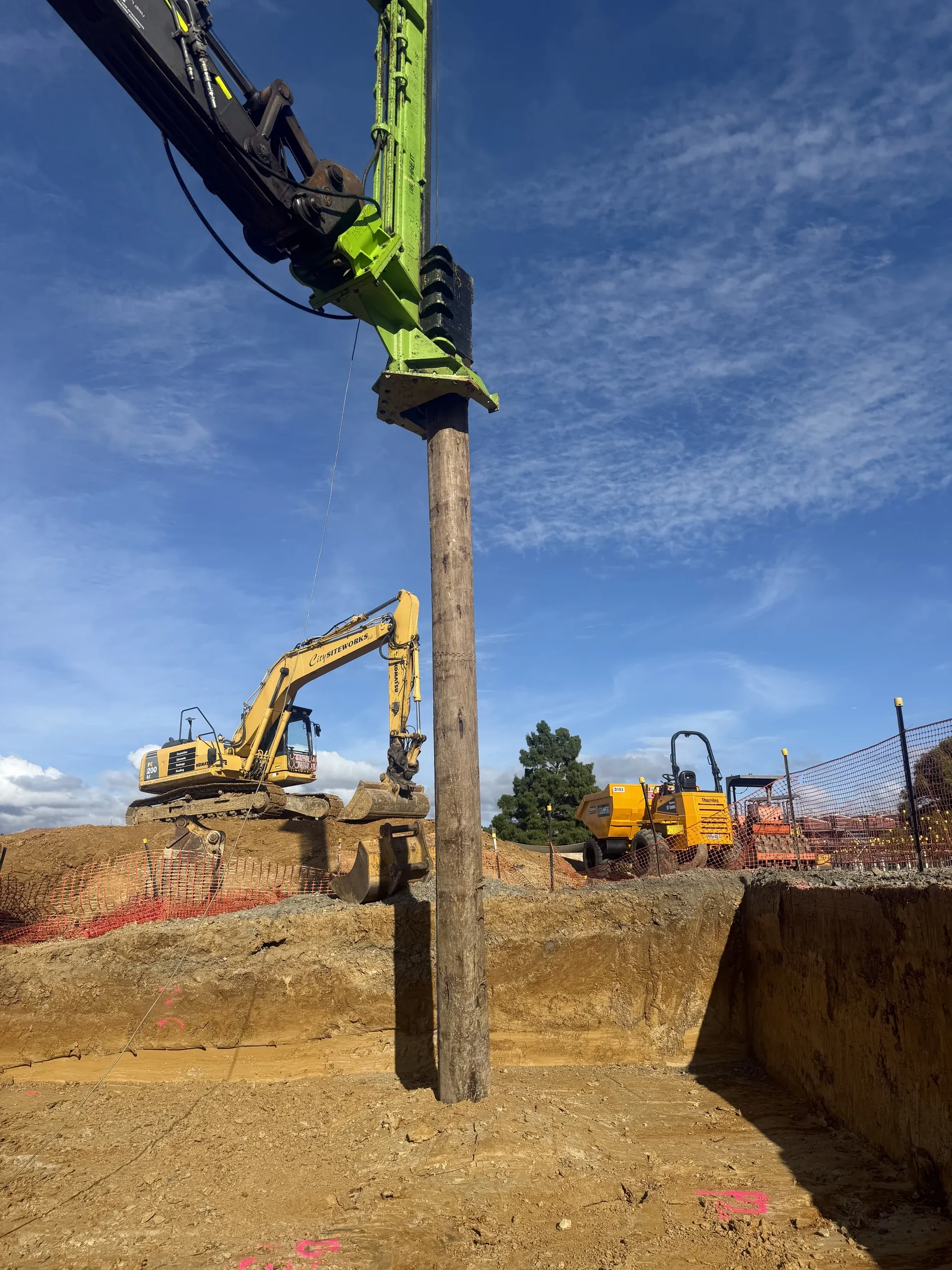 Excavator setting a retaining post into position during the Glen Innes retaining works.