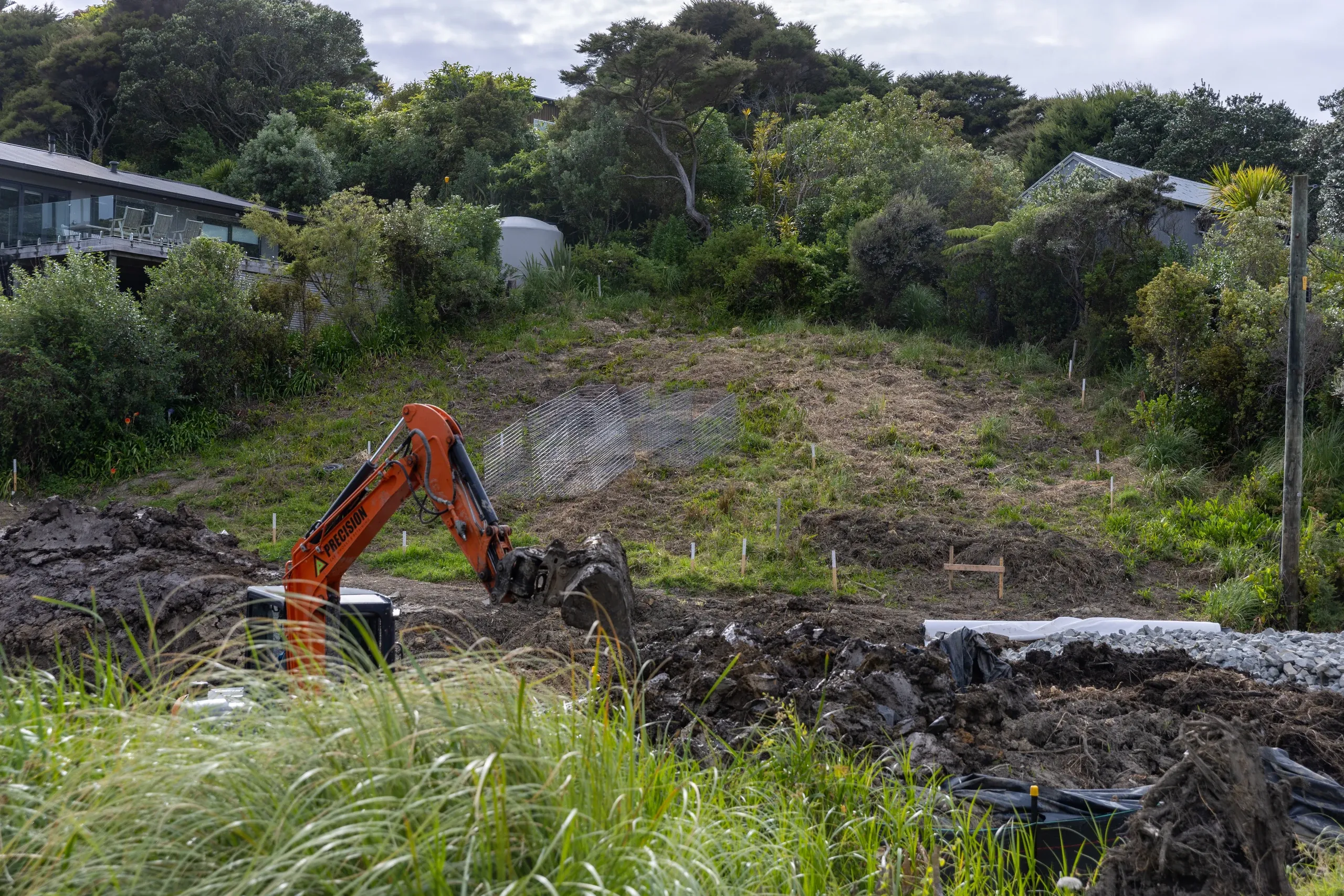 The excavator working across the cleared platform, the full width of the terrace now open.