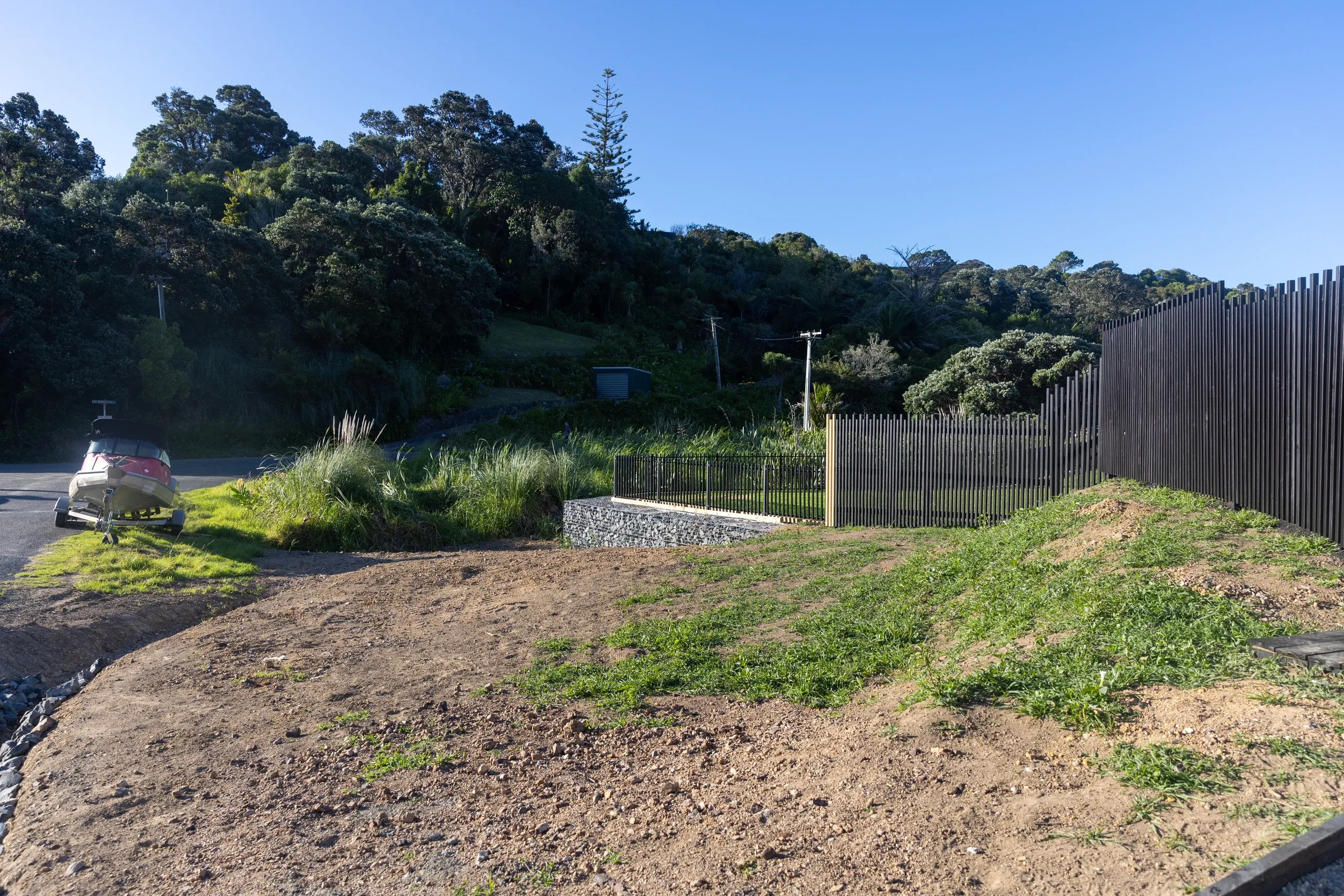 The completed driveway and fence line, the reshaped ground tying into the existing boundary.
