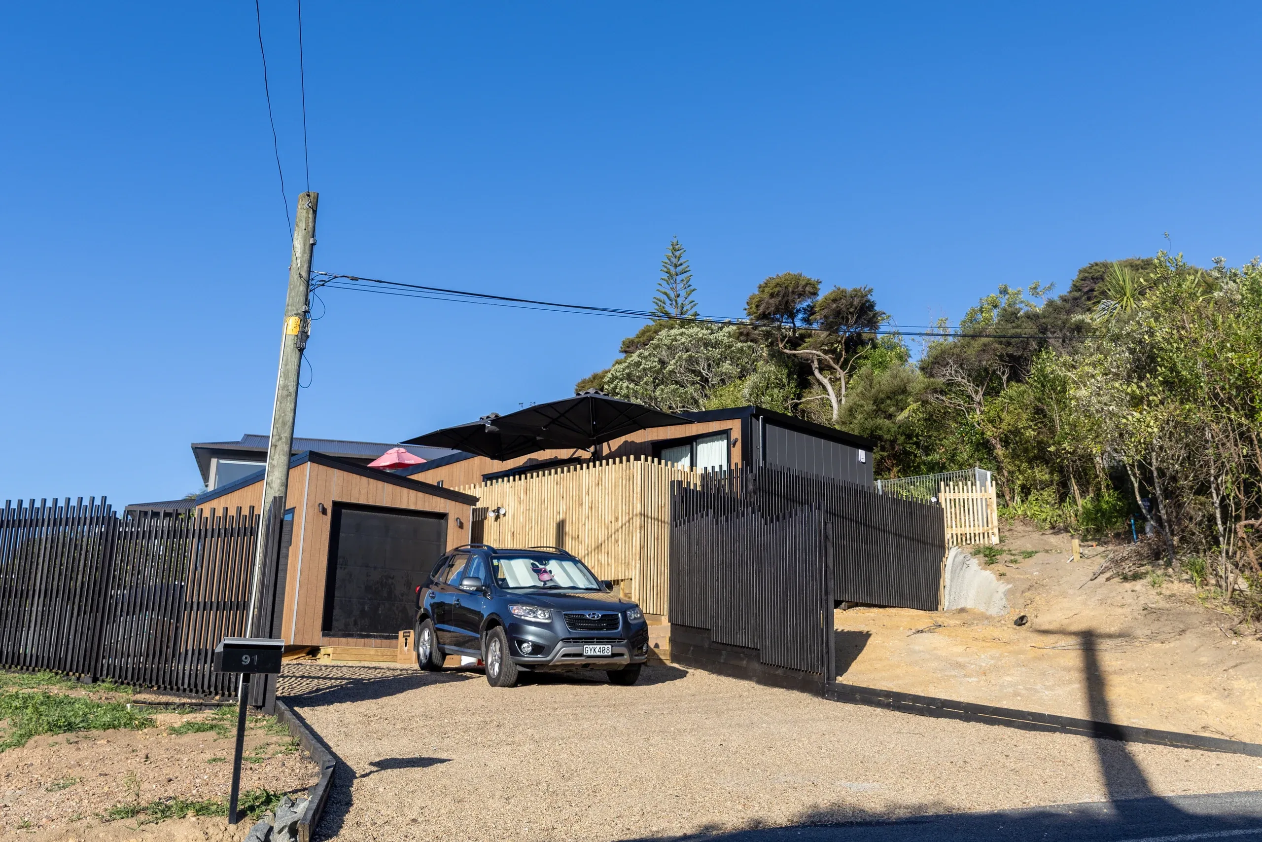 The completed gabion wall with fencing set along the top and the terrace levelled behind it.